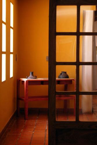 a room with a table with two vases on it at Hotel de Las Nubes in San Antonio de los Cobres