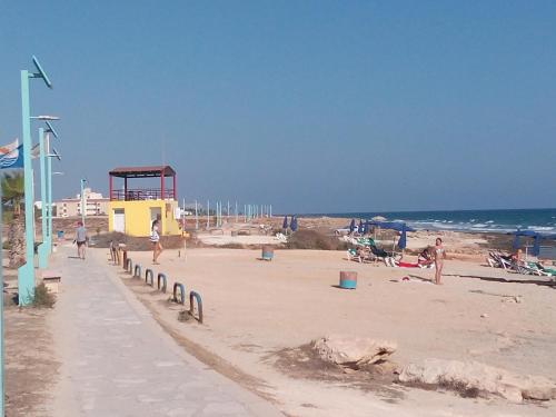 a beach with a lifeguard tower and people on the beach at SUNSHINE APTS, TWO BEDROOM , FREE INTERNET, No 3 in Ayia Napa