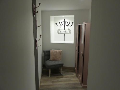 a hallway with a chair and a picture on the wall at Entre Nous - La Poste in Saumur