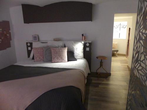 a bedroom with a bed with white sheets and pillows at Entre Nous - La Poste in Saumur