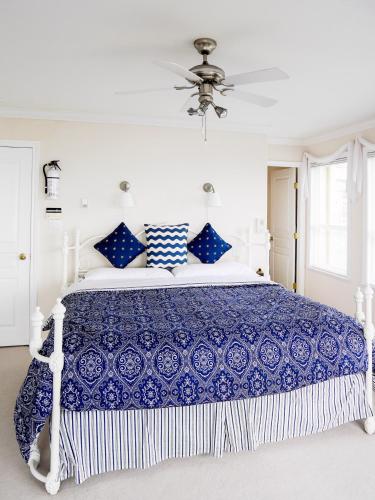 a blue and white bed in a white bedroom at Star of the Sea guest house in White Rock