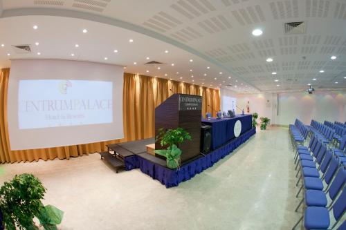 a conference hall with blue chairs and a stage at Centrum Palace Hotel & Resorts in Campobasso