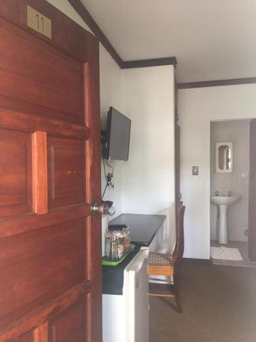 a room with a kitchen with a sink and a door at Villa Grande Lodge in Louis Trichardt