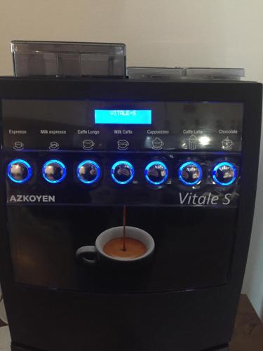 a black coffee machine with a cup of coffee at Penzion Ema B&B in Prostějov