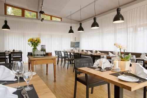 Seehörnle Bio Hotel & Gasthaus في غاينهوفن: غرفة طعام مع طاولات وكراسي ونوافذ