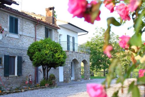a stone house with pink flowers in front of it at Agriturismo Re Piano in Modigliana