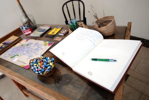 a table with an open book and a pen on it at La Casa de Las Titas in Vélez-Málaga