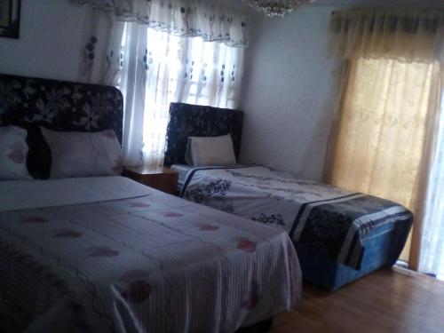 sypialnia z 2 łóżkami w pokoju z oknami w obiekcie Guest House Macauly w mieście Johannesburg