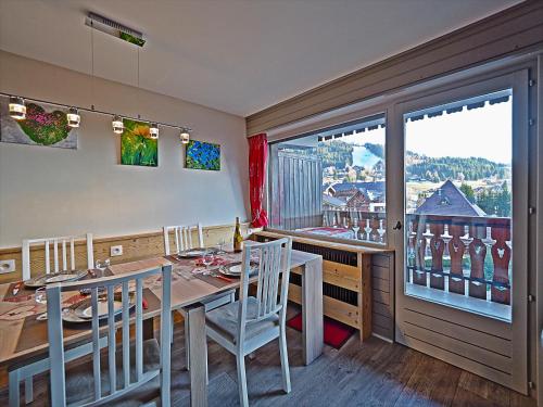 une salle à manger avec une table et des chaises et une fenêtre dans l'établissement BelleVue centre, wifi, mountain view, aux Carroz d'Arâches