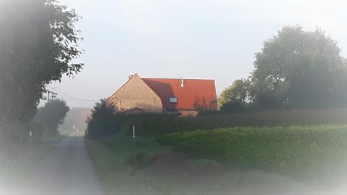 a house on the side of a road next to a field at B&B Haere Mai in Loker