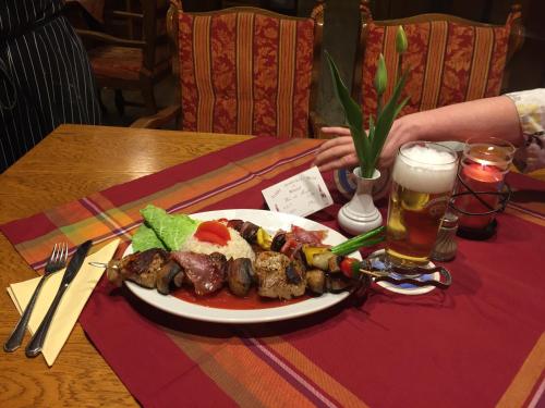 a plate of food on a table with a glass of beer at Tutzinger Hof in Tutzing