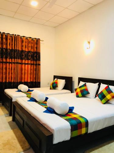 two beds in a room with twothirds at Pearl House Resort in Anuradhapura