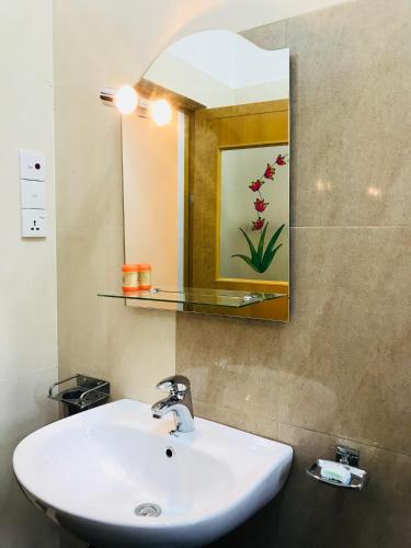 a bathroom with a white sink and a mirror at Pearl House Resort in Anuradhapura