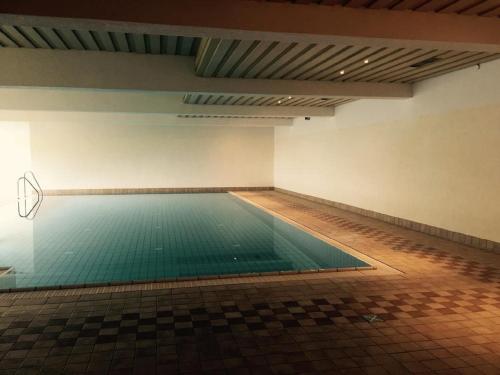 a swimming pool in an empty room with a tile floor at Am Berg 34 in Maria Alm am Steinernen Meer