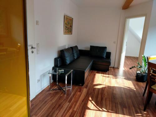 a living room with a black couch and a table at Ferienwohnung "Zum Klosterruinenblick" in Kröv