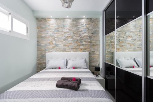 a bedroom with a bed and a brick wall at Orlando Apartment La Laguna 2 in Adeje