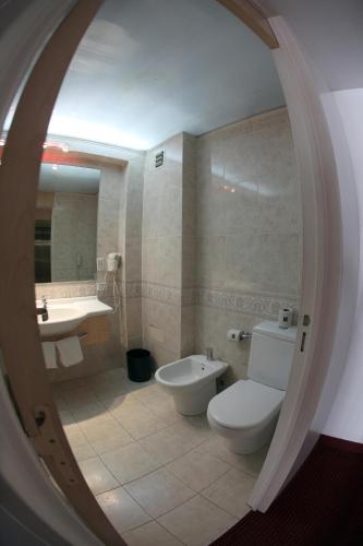 a bathroom with a toilet and a tub and a sink at Cristal Palace Hotel in Buenos Aires