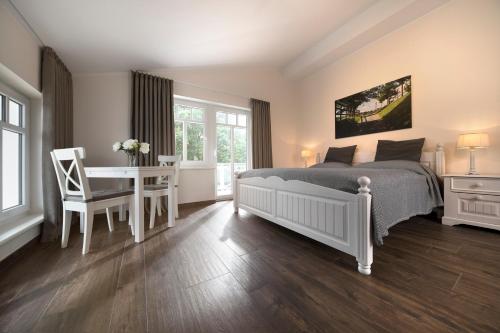a bedroom with a bed and a table and a desk at Reiterhof und Pension Eichenhof in Haiger