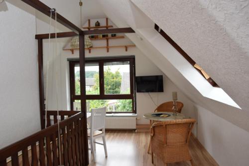 Habitación con escalera, mesa y ventana. en Pension Heister, en Isselburg