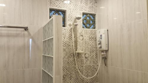a shower in a bathroom with a glass door at Batu Ferringhi Seaview Apartment in Batu Ferringhi
