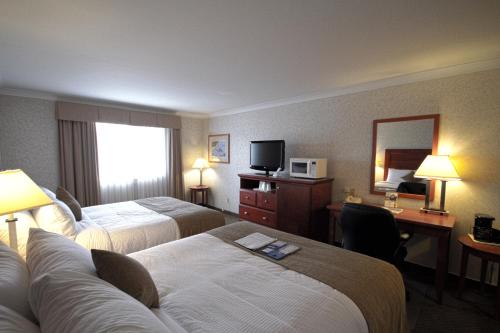 a hotel room with two beds and a desk at Best Western Gold Rush Inn in Whitehorse
