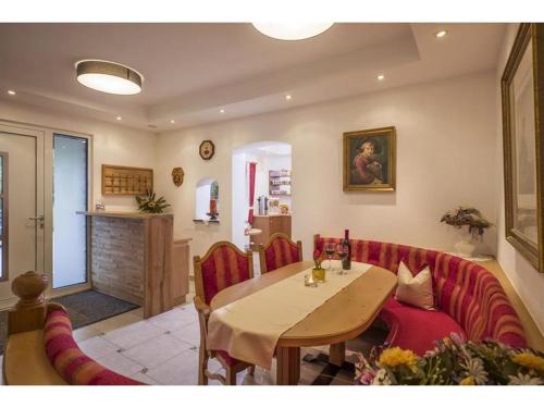 a living room with a table and a red couch at Pension Waldegg in Hippach