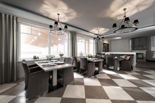 a dining room with tables and chairs and a checkered floor at Reiterhof und Pension Eichenhof in Haiger