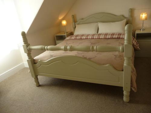 a white bed in a room with two lamps at Aberlour Cottages - Bolthole & Retreat in Aberlour