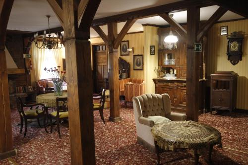 a living room with a couch and a table and chairs at Kiermusy Dworek nad Łąkami in Kiermusy