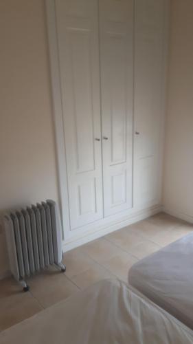 a white room with a radiator and a bed at Casa Patrick in Murcia