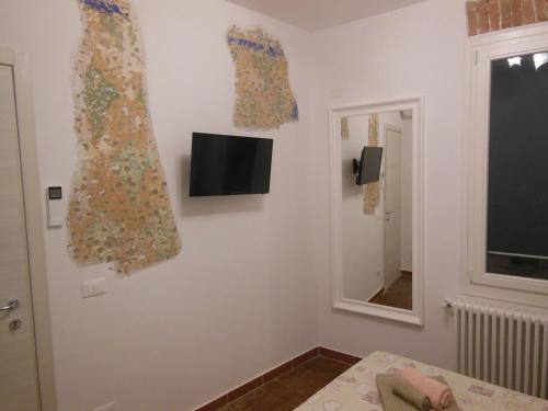 ボローニャにあるLa Petroniana Homeの窓のある壁にテレビが備わる客室です。
