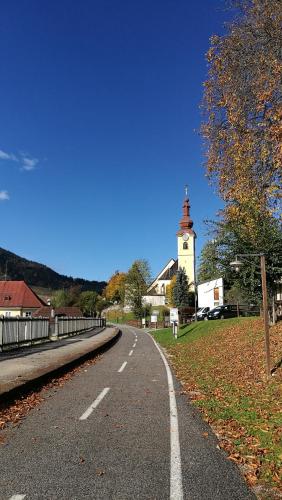 an empty road with a lighthouse in the distance at NeStop FVG in Tarvisio