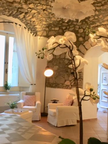 a living room with white furniture and a tree in it at S'O Smart B&B Tropea in Tropea