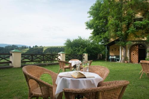 a table with chairs and a table with a book at Hotel Landsitz Pichlschloss in Neumarkt in Steiermark