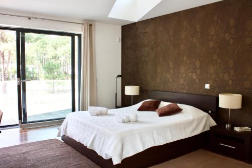 a bedroom with a bed with two towels on it at Design House Aroeira Golf in Charneca