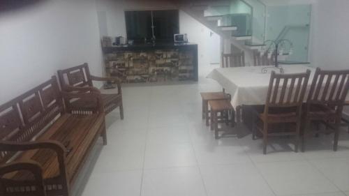 a dining room with a table and wooden chairs at Escarpas, Capitólio, Bloco 13 casas in Capitólio