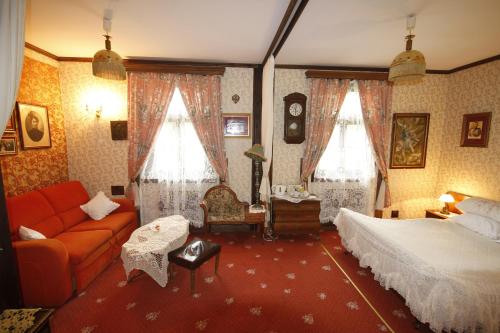 1 dormitorio con 1 cama y 1 sofá en Kiermusy Dworek nad Łąkami, en Kiermusy