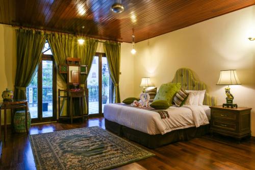 a bedroom with a bed and a wooden ceiling at 5 Heeren Museum Residence in Melaka