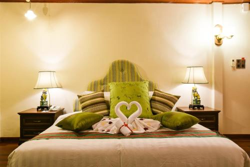 a bedroom with a bed with a heart on the pillows at 5 Heeren Museum Residence in Melaka