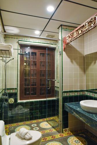 a bathroom with a shower and a toilet and a sink at 5 Heeren Museum Residence in Melaka