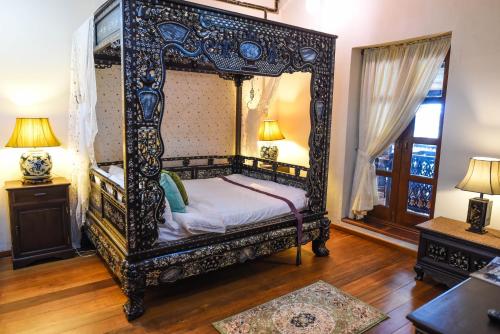 a bedroom with a canopy bed in a room at 5 Heeren Museum Residence in Melaka