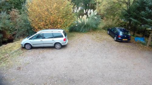 two cars parked in a gravel parking lot at Bluebell Cottage in Tarbert