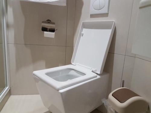 Un baño con un inodoro blanco y un lavabo. en La Signature Guest house, en Francistown