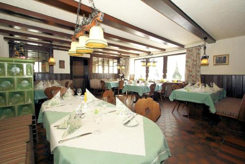 a dining room with tables with green tablecloths at SchöpPerle in Häusern