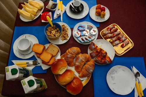 a table topped with plates of bread and pastries at Terrazzo su Ibla in Ragusa