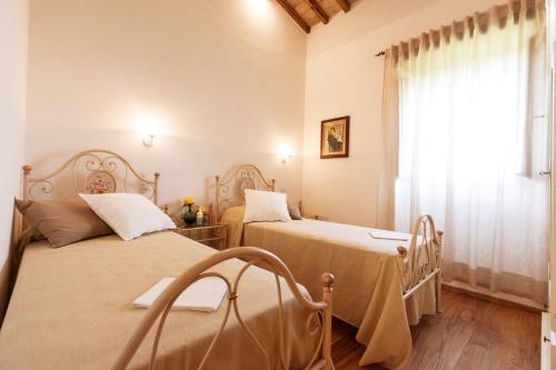 Duas camas num quarto com uma janela em Casa Uliveto in Molino Vitelli em Casella
