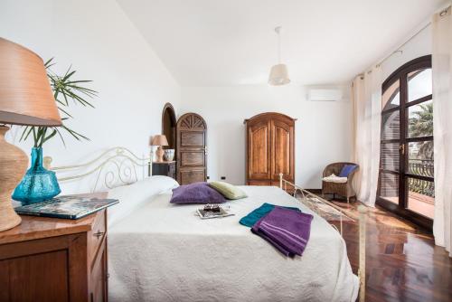 a bedroom with a bed and a table with a lamp at villa Maiani Travelmoods villas in Mazara del Vallo