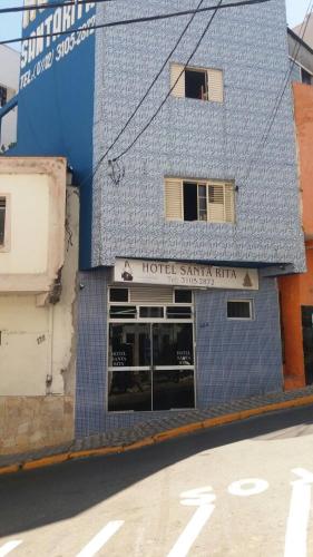 a building with a blue tile facade on a street at Hotel Santa Rita in Aparecida