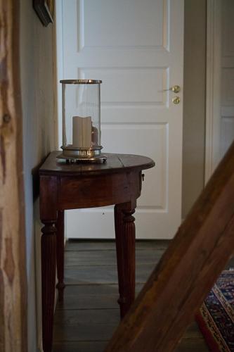 a wooden table with a lantern on top of it at Ladugårdens Pub & Sal in Enhörna