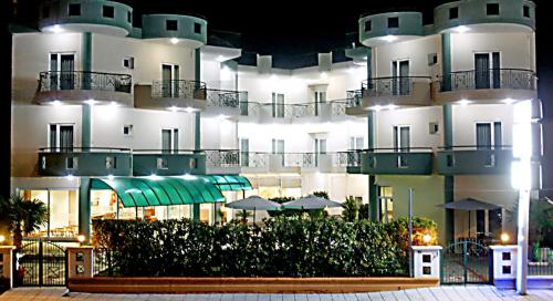 a large white building with umbrellas in front of it at Hotel Filoxenia Beach in Leptokaria